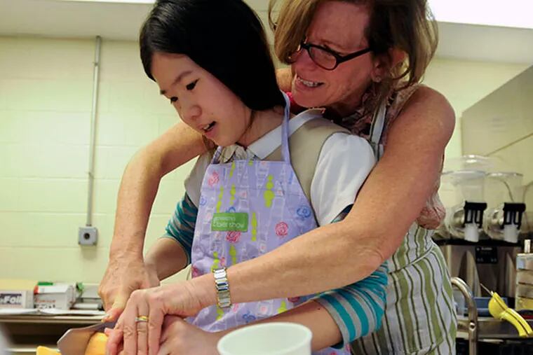 Maureen helps Kimberly Luu slice a sweet potato to make sweet potato and carrot soup on April 9, 2014. ( RON TARVER / Staff Photographer )