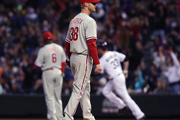 Kyle Kendrick, front, calls for a new ball after giving up a two-run home run to Colorado Rockies' Justin Morneau, back right, as Phillies first baseman Ryan Howard, back left, looks to see where the ball landed in the fourth inning of a baseball game in Denver on Saturday, April 19, 2014. (David Zalubowski/AP)