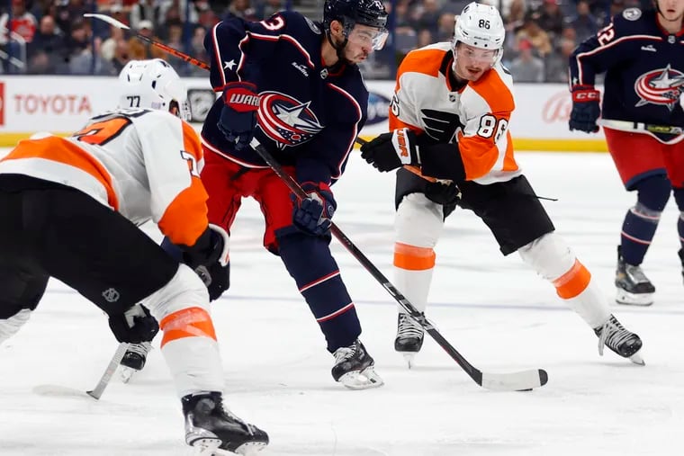 Columbus Blue Jackets forward Johnny Gaudreau (center) controls the puck between Philadelphia Flyers defenseman Tony DeAngelo and forward Joel Farabee in the second period. Gaudreau scored and had two assists Thursday night.