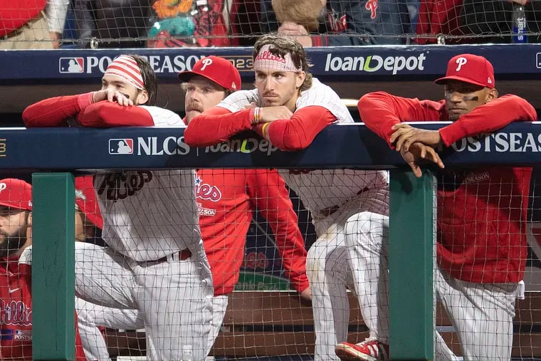 The Phillies look on from the dugout as the Diamondbacks celebrate winning the NLCS in Game 7.