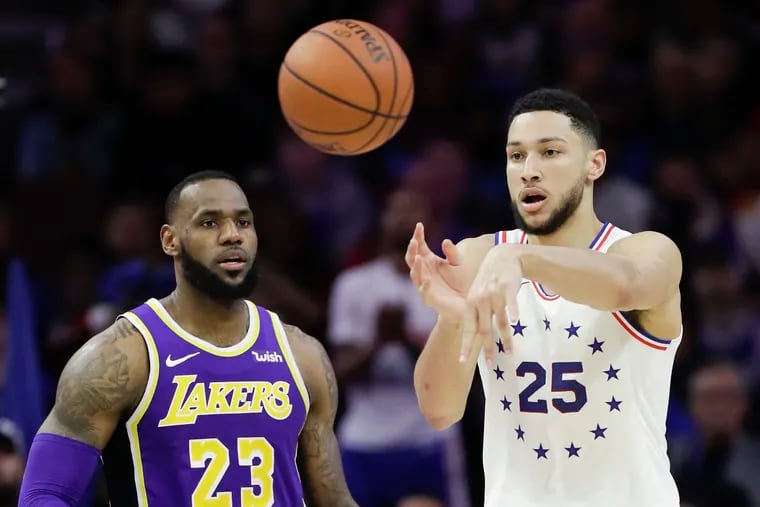 Sixers guard Ben Simmons passes the basketball against Los Angeles Lakers forward LeBron James on Sunday, February 10, 2019 in Philadelphia.