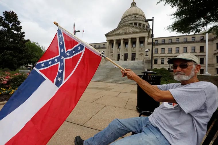 Larry Eubanks of Star waves the current Mississippi state flag as he sits before the front of the Capitol, Saturday, in Jackson, Miss. While a supporter of the current flag, Eubanks says he would hope lawmakers would allow a proposed flag change to be decided by the registered voters. The current state flag has in the canton portion of the banner the design of the Civil War-era Confederate battle flag, that has been the center of a long-simmering debate about its removal or replacement.