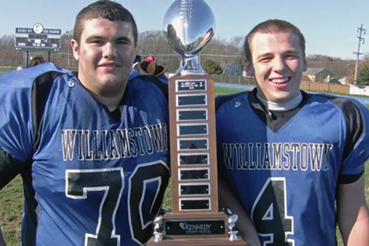 Williamstown’s Mike Martucci, left, and John Chamberlin hold the trophy given to winner of the Thanksgiving game. (Marc Narducci/Staff)