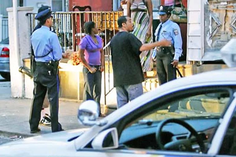 12th District Philadelphia Police officers question residents on the 2000 block of Avondale street in Southwest after a vandalism/man with a gun call, Friday. ( Steven M. Falk / Daily News)