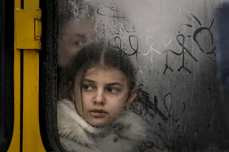 A child looks out a steamy bus window as civilians are evacuated from Irpin, on the outskirts of Kyiv, Ukraine, earlier this year. Millions of people have been driven out of Ukraine by the Russian invasion.