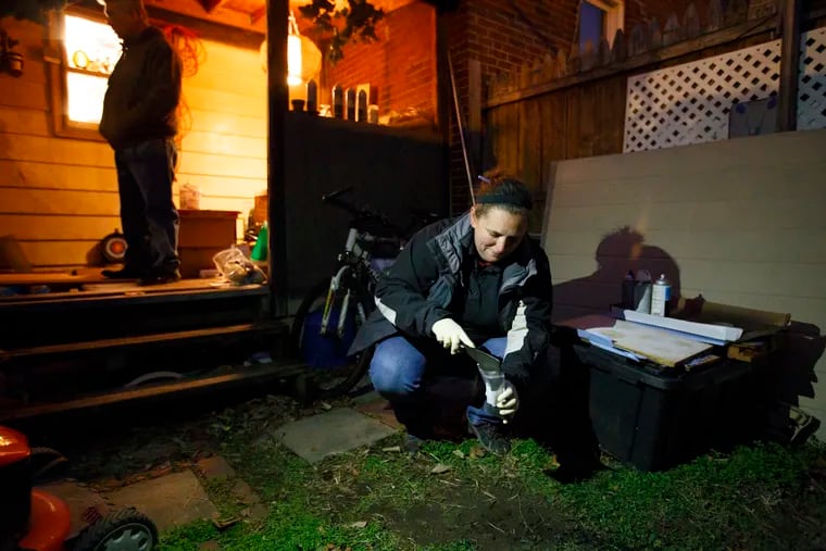 Melissa Billingsley, a state licensed risk assessor for Criterion Laboratories, takes a soil sample in a yard located on the 2600 block of East Thompson street, on December 12, 2016. The yard tested high for lead.