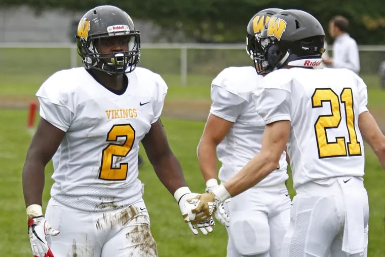 Archbishop Wood running back Leroy Pendleton (2) gets congratulated by teammate Brad Otto (21) after his 70-yard scoring run in a 27-7 win over Archbishop Ryan on Oct. 6.