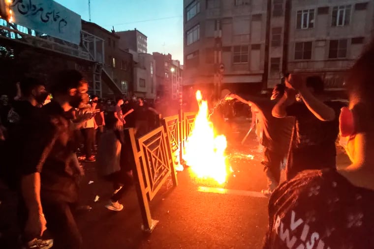 Protesters make fire and block the street during a protest over the death of a woman who was detained by the morality police, in downtown Tehran, Iran on Sept. 21, 2022.
