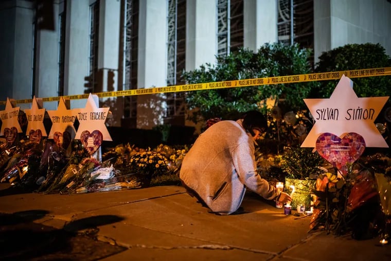 A woman leaves a candle in front of the Tree of Life synagogue in Pittsburgh on Oct. 29, 2018. Eleven people were killed during a mass shooting at the synagogue two days earlier.