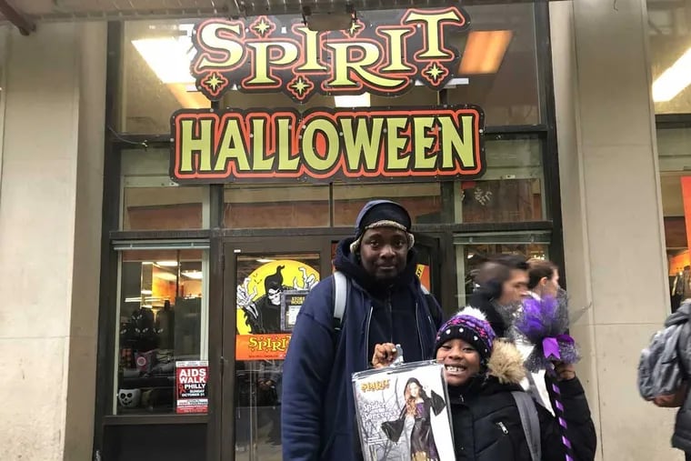 Kevin Corbett, 48, and his daughter Erica Corbett, 7, buy a Halloween costume at the Spirit Halloween on Chestnut Street on Friday. October 26.