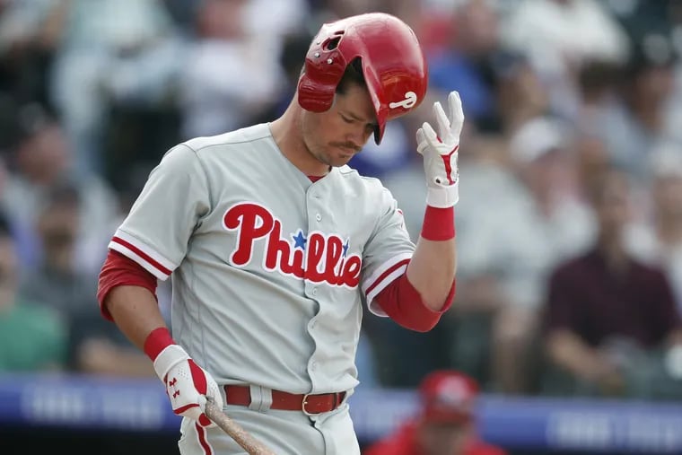 The Phillies' Andrew Knapp reaching to catch his helmet after swinging at a pitch from Rockies reliever Adam Ottavino in the eighth inning Thursday.