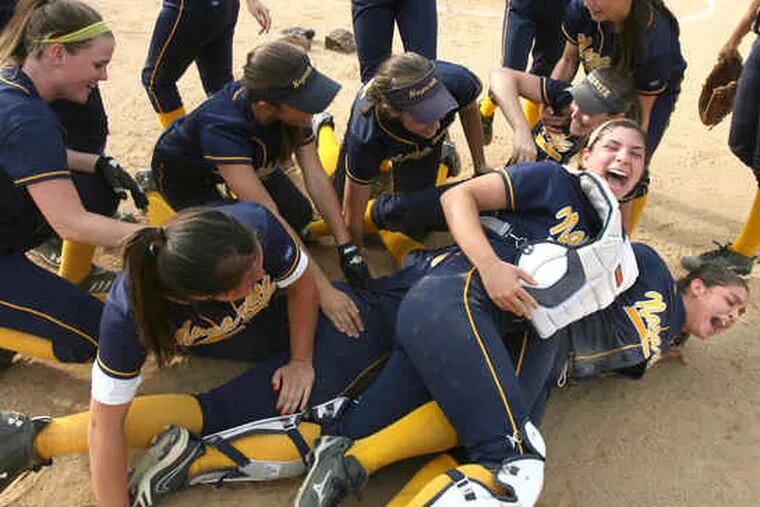 Winning pitcher Erica Cipolloni (right) and catcher Alicia Keough (second from right) join the pileup of bodies as Nazareth Academy players celebrate their Catholic Academies softball championship after defeating Villa Maria, 3-0.