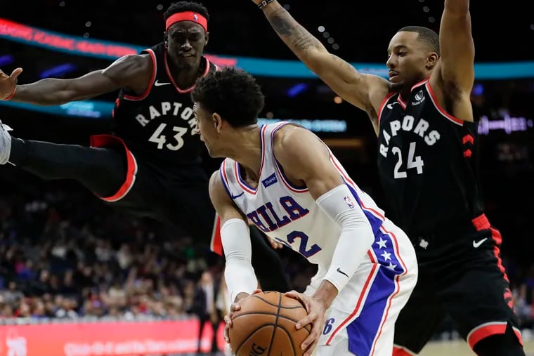 Sixers guard Matisse Thybulle gets caught in the corner during a fourth-quarter double team by Toronto Raptors guard Norman Powell (right) and forward Pascal Siakam.