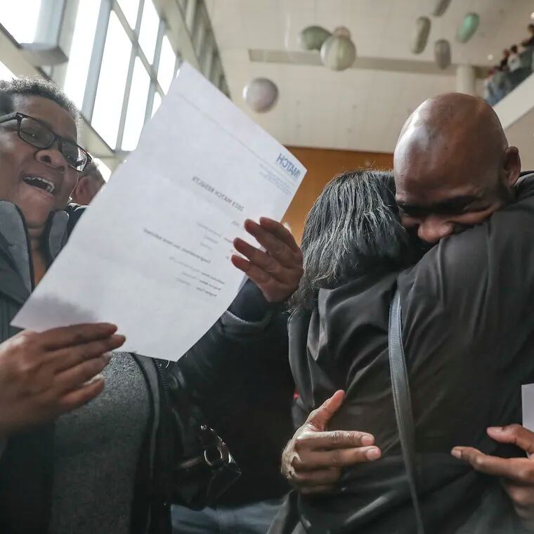 Demetrius Woodard hugs his mother, Denise Woodard, while his aunt, Cheryl Sully, reads his match results during a Match Day celebration at the Lewis Katz School of Medicine at Temple University in mid-March.