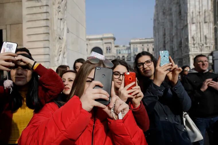 Even young women, like these teens outside Alberto Zambelli women's Fall-Winter 2019-2020 fashion show, in Milan, may find that the unusual angles often involved in taking selfies can be less than flattering. (AP Photo/Luca Bruno)