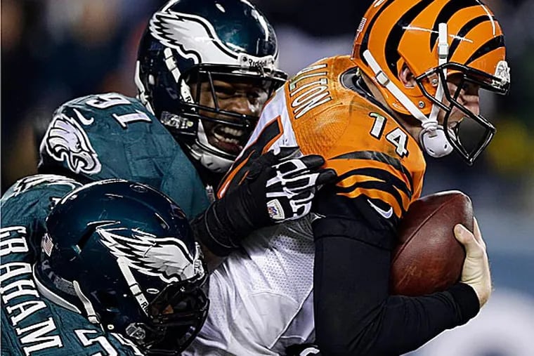 The Bengals' Andy Dalton is sacked by the Eagles' Brandon Graham, left, and Fletcher Cox. (Matt Rourke/AP)