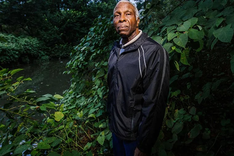Eastwick community activist Earl Wilson stands at the edge of the elevated Darby Creek after heavy rains on Saturday, October 3rd, 2015 in Southwest Philadelphia. (MICHAEL BUCHER / For the Inquirer)