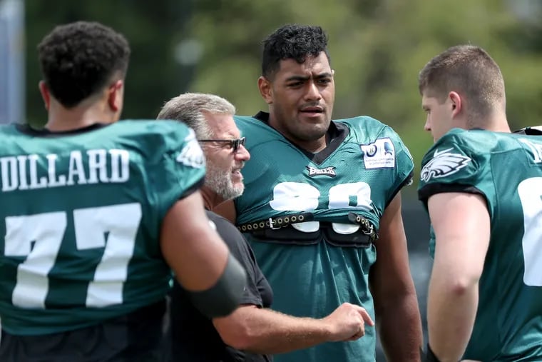 Eagles tackles Jordan Mailata (center) listens to instruction from offensive line coach Jeff Stoutland, with rookies Andre Dillard and Brett Toth.