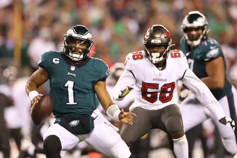 Eagles quarterback Jalen Hurts races past Tampa Bay Buccaneers outside linebacker Shaquil Barrett during the second quarter on Thursday, October 14, 2021 in Philadelphia.