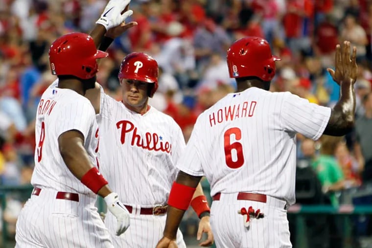 Domonic Brown (left) is congratulated on his three-run home run by Michael Young (center) as Ryan Howard, who scored, heads to the dugout during the first inning of a baseball game with the New York Mets, Wednesday, April 10, 2013, in Philadelphia. (Tom Mihalek/AP)