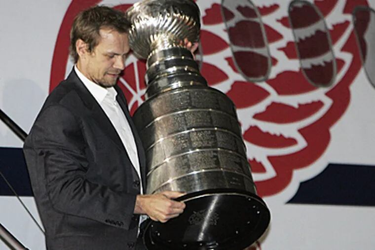 Detroit Red Wings caption Nicklas Lidstrom, of Sweden, carries the Stanley Cup off of the plane. (AP)