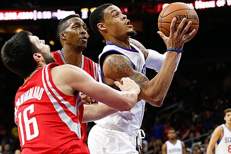 76ers guard K.J. McDaniels is fouled as he attempts to score past Rockets forward Kostas Papanikolaou and center Dwight Howard. (Bill Streicher/USA Today Sports_