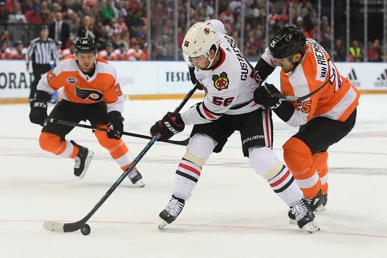Chicago Blackhawks defenseman Erik Gustafsson, left, and Flyers left winger James van Riemsdyk battle for the puck during the season opener last Oct. 4 in Prague. The Flyers signed Gustafsson on Monday to a one-year deal.