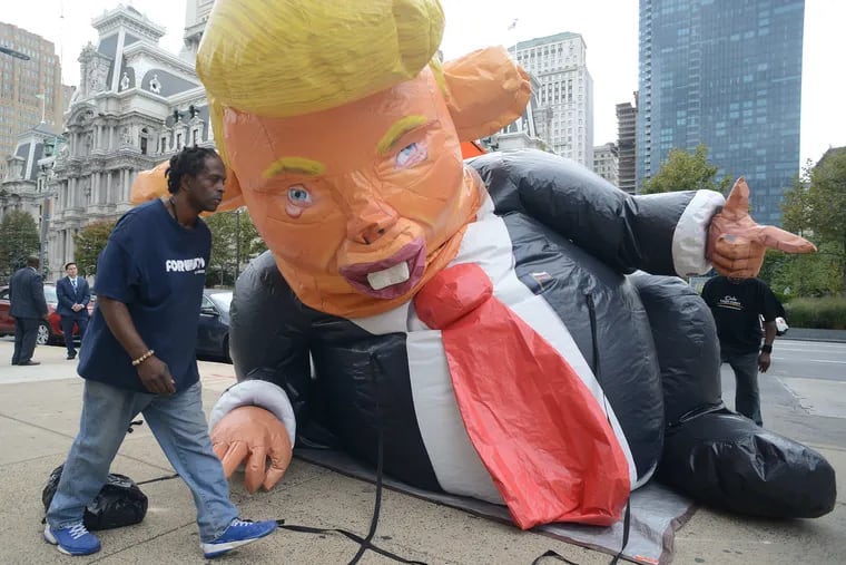 Justice for ATTAC sets up the Trump Rat, by John Post Lee near the Frank Rizzo sculpture Monday, October 23, 2017 at Thomas Paine Plaza in Philadelphia, Pennsylvania.