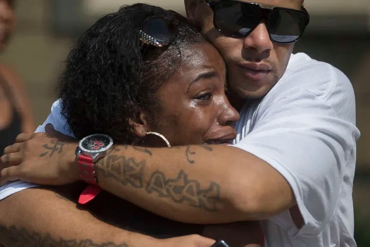 Shanicca Soloman cries in the arms of Terrell Whitney outside the funeral for Samuel DuBose in Cincinnati.