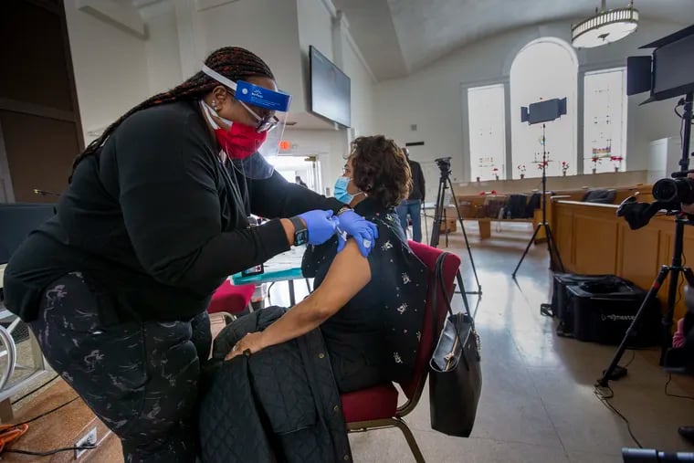 Erika Gregg, Clinical Lead, vaccinates Arleathia Marshall, wife of Pastor Warren H. Marshall, Jr. (not shown) of North Penn Baptist. Black church leaders and parishioners were vaccinated at Salem Baptist Church in Abington, PA on Tuesday.