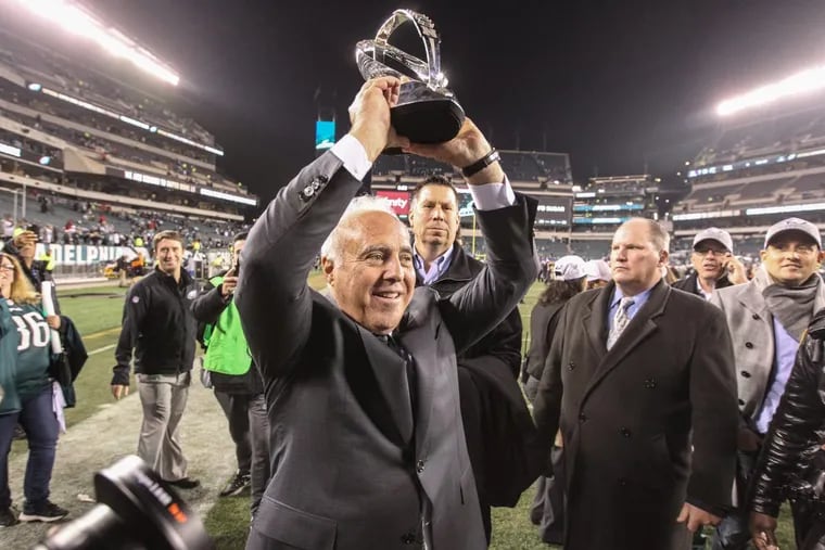 Eagle owner Jefffrey Lurie shows off the NFC Championship trophy to the fans at Lincoln Financial Field as the and the team walk off after beating the Vikings 38-7.