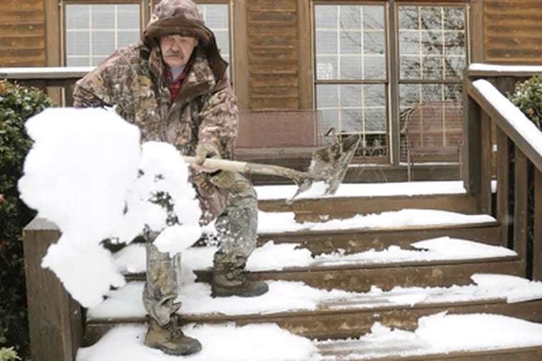 Jim Ellerbee clears snow and ice from the steps of his home in Springville, Ala. on Tuesday. (AP Photo/The Birmingham News, Joe Songer)