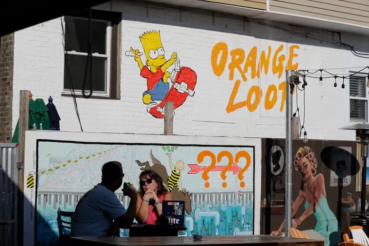 Diners sit outside at the Tennessee Avenue Beer Hall with art work from the beer hall and neighbors during happy hour in Atlantic City on Thursday, August 18, 2022. The Orange Loop is part of Atlantic City's new "Green Zone," for cannabis.