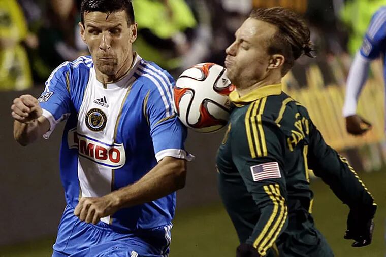 Union forward Sebastien Le Toux, left, and Portland Timbers defender Michael Harrington battle for the ball during the first half of an MLS soccer game in Portland, Ore., Saturday, March 8, 2014. (Don Ryan/AP)
