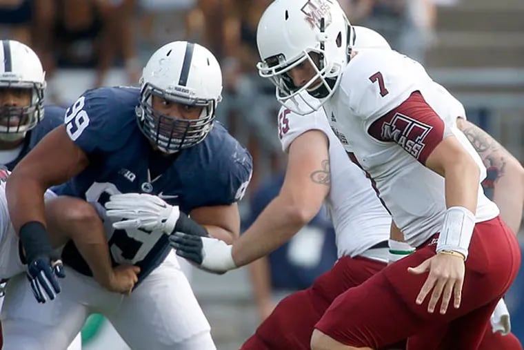 Massachusetts quarterback Blake Frohnapfel (7) fumbles he snap as Penn
State defensive tackle Austin Johnson (99) pressures in the first quarter of an NCAA football game on Saturday, Sept. 20, 2014, in State College, Pa.  Penn State won 48-7. (Keith Srakocic/AP)