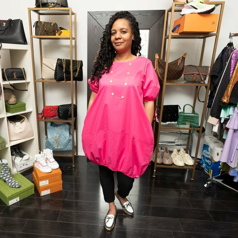 Chanel Young, left, tries on a pink bubble dress with Shani Newton, right, the owner of Dolly’s Boutique, at the Boutique, in Mt. Airy, Friday, March 24, 2023.