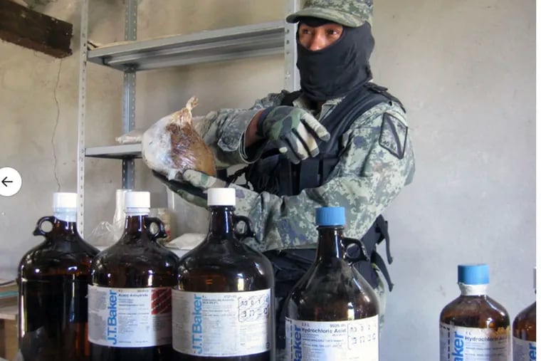 Mexican security officer with jugs of acetic anhydride, the chemical used during the process to turn opium into heroin, made by the J.T. Baker unit of Radnor-based chemical maker Avantor, in November 2010, shortly after the company was reorganized under chairman Rajiv L.Gupta.  Avantor said on Sept. 15, 2020,  that it stopped selling the chemical in Mexico and destroyed supplies after learning from reporting in Bloomberg Businessweek that its chemical, whose use is carefully controlled in the U.S. and other countries, was sold over the counter by drugstores and other retailers in Mexico City and in opium-growing, heroin-producing states such as Sinaloa and Guerrero. (Photo: Oscar Alvarado / Cuartoscuro.com)