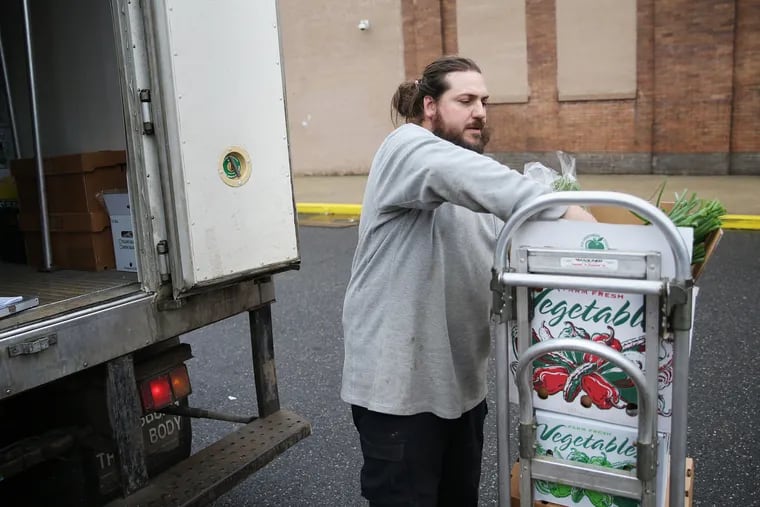 Green Meadow Farm co-owner Ian Brendle unloads a delivery of produce for Elwood in Fishtown. Green Meadow Farm usually works with restaurants, but in the wake of a shutdown, it is offering farm share boxes to the general public.