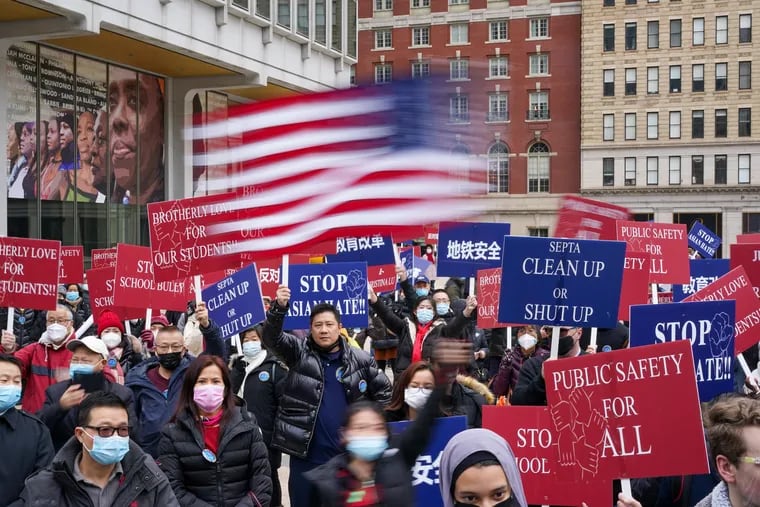 A woman waves an American flag at a rally to stop Asian hate in Philadelphia. The rally was held for Christina Lu, an Asian American high school student, who was assaulted on the subway on Nov. 17.