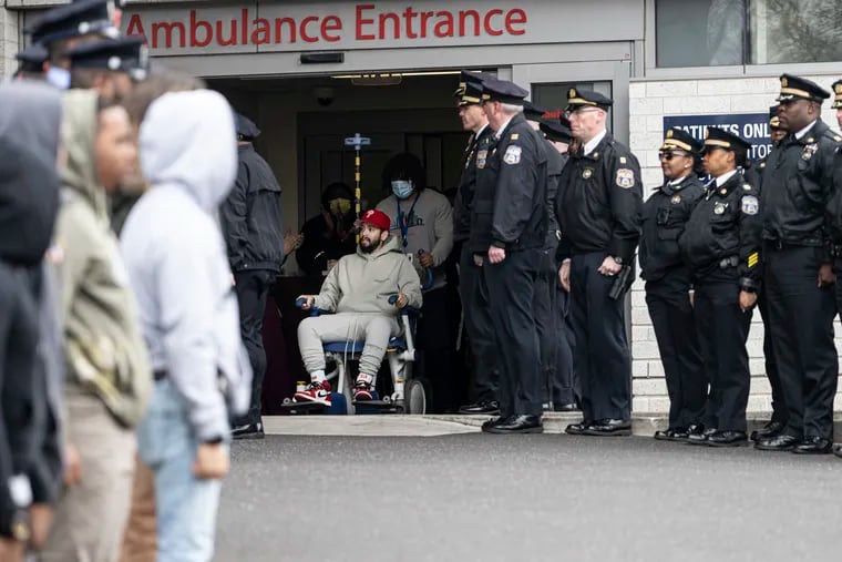 Officer Giovanni Maysonet leaves Penn Presbyterian Hospital on Tuesday as members of the Philadelphia Police Department line up outside to wish him a complete recovery. Maysonet was shot in the line of duty on Feb. 8 during a vehicle investigation on the 200 block of North 60th Street. .