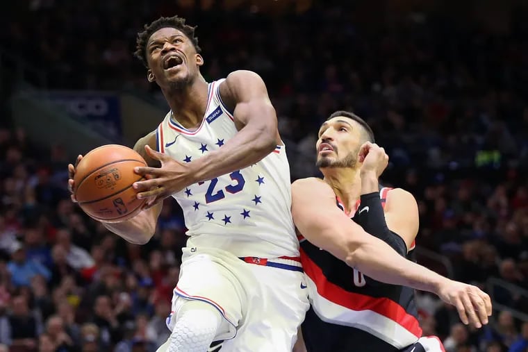 The Sixers' Jimmy Butler (23) goes for a layup past the Portland Trail Blazers' Enes Kanter (00) during a game at the Wells Fargo Center in South Philadelphia on Saturday, Feb. 23, 2019. The Sixers lost 130-115.