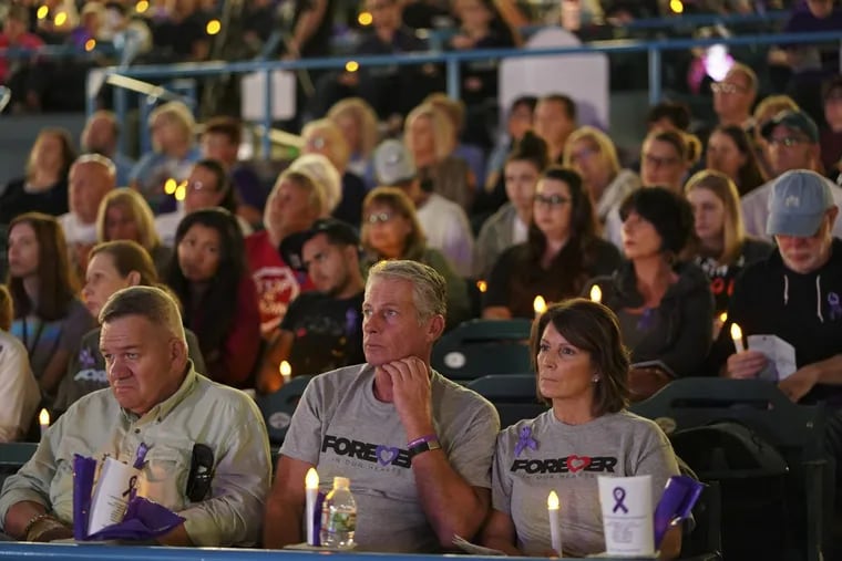 People listen to speakers as they participate in a candlelight vigil in honor of opioid overdose victims.