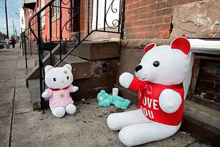Teddy bears and candles on the stoop of 4018 N. Fairhill St., where an apparent murder-suicide Wednesday night has orphaned five children. (Laurence Kesterson / Inquirer)