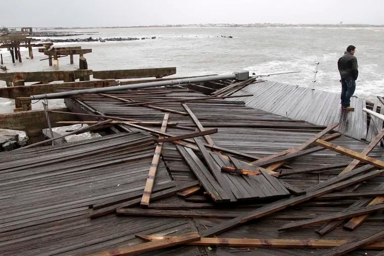 Nicholas Rodriguez looks over a section of the destroyed boardwalk in Atlantic City on Oct. 30, 2012, not far from where a powerful storm that started out as Hurricane Sandy made landfall. A new report by First Street Foundation projects more tropical cyclones will turn into major hurricanes, pushing farther into the Northeast.