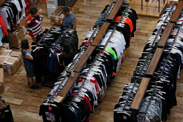 People try garments at a retail and wholesale clothing mall in Beijing.