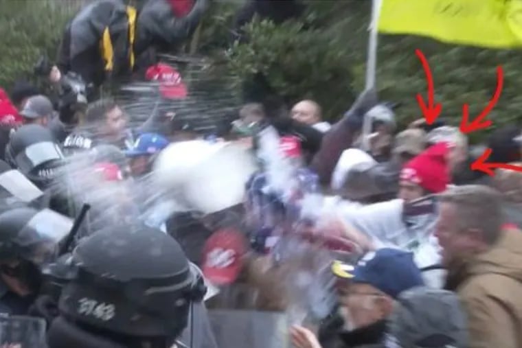 The FBI arrested Michael Dickinson, 30, of Philadelphia on Wednesday for his involvement in the Jan. 6 Capitol riot. Charging documents included this photo, which prosecutors say is Dickinson throwing a bucket of water on police.