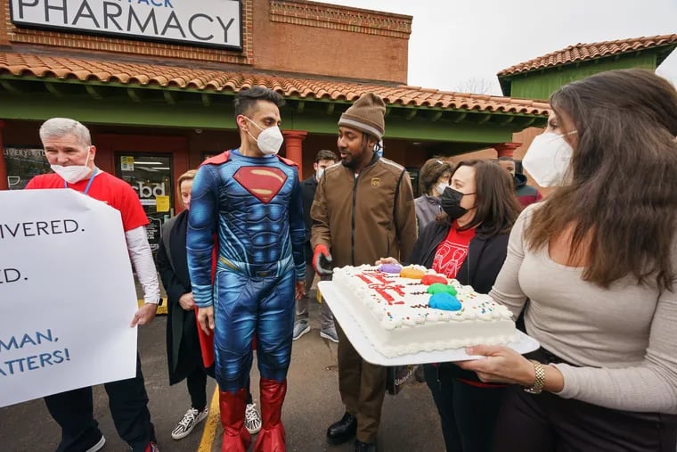 UPS driver Terron Coleman, center right, talks with Mayank Amin, center left, owner of Skippack Pharmacy, during a celebration event held by Skippack Pharmacy to recognize Coleman for his role in delivering PPE and vaccines throughout the pandemic.