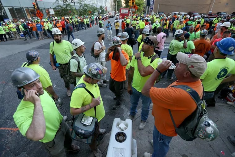 Union workers gather outside the construction site as union crane operators protest in front of the Comcast tower June 30.