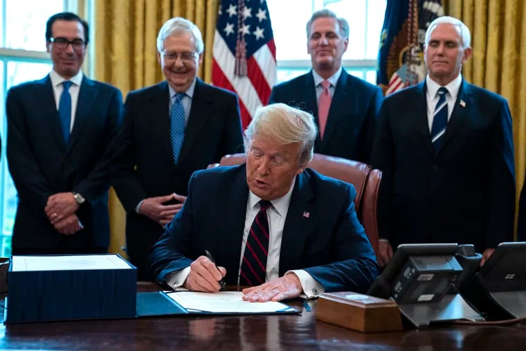 In March, President Donald Trump signs the first coronavirus stimulus relief package in the Oval Office. Congress has approved a second stimulus bill that awaits his signature.