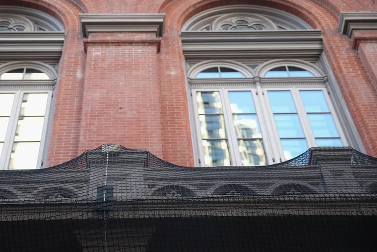 Netting on the front balcony of the Academy of Music has been placed as a precautionary measure to keep chipped or splintering exterior finishes from falling.